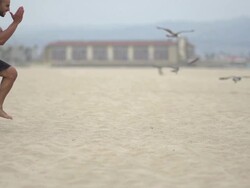 A man doing speed and agility training on the beach with a parachute.  - Super Slow Motion - filmed at 240 fps Stock Footage