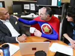MS PAN Man dressing in blue superhero outfit with red cape congratulates business man sitting next to him and shakes his hand / Seattle, Washington, United States  Stock Footage