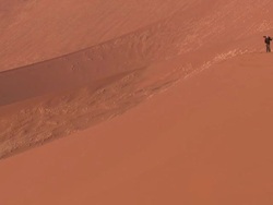 Man with tripod walking on sand dune, Sossusvlei, Namib-Naukluft, Namibia Stock Footage