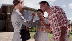 Realtor shaking hands with happy couple in front of house with Sold sign Stock Footage