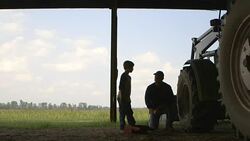 Caucasian father explaining tractor repair to son Stock Footage