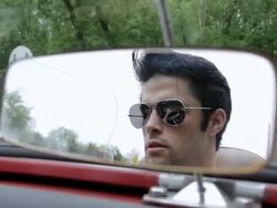 MS  young man wearing sunglasses driving convertible car in rural area visible through  rear view mirror / Bayport, Minnesota, United States Stock Footage