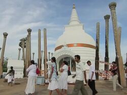 MS Worshippers passing Thuparama Dagoba, the first dagaba built in Sri Lanka after introduction of Buddhism, contains collarbone of Buddha / Anuradhapura, North Central Province, Sri Lanka Stock Footage