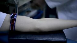 technician inserts needle into blood donor's arm, taking blood tests in blood bank laboratory in hospital Stock Footage