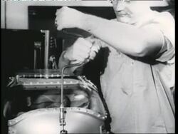 A scientist locks a chimpanzee in a space capsule. News Clip