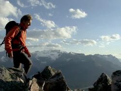 WS, PAN, mountain climber walking across mountain ridge, Banff National Park, Alberta, Canada Stock Footage