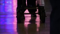 A traveler pushes a cart through an airport terminal. Stock Footage