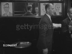 1952: SARDI'S RESTAURANT: MANHATTAN, NEW YORK: VS Male restaurant greeter greeting guests, people, in Sardi's Restaurant, caricature drawings hanging on wall BG, REPEATED TAKES. NYC, West 44th Street Instructional Video