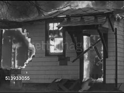 1953: BURNING HOUSE: Angled MS Single story wood frame house on fire in rain, window & front wall burned, support beams inside home flaming, strong flames inside by front door like accelerant, small wood beam from porch falling. Instructional Video