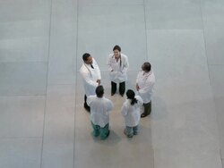 WS Five physicians in labcoats are standing in circle having informal meeting and walk out / Seattle, Washington, USA Stock Footage