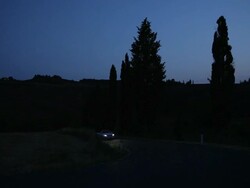 WS PAN Car driving down treelined road at dusk / Tuscany, Italy Stock Footage