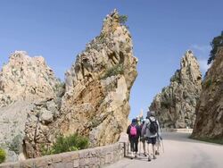 MS Shot of Hiker on the road through the fantastic rock landscape of the Calanche of Piana, UNESCO World Heritage Site / Gulf of Porto, Corsica, France Stock Footage