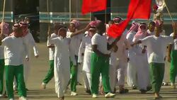 Protestors march with colorful flags in Saudi Arabia. Stock Footage