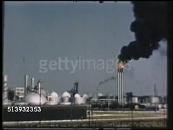 1950: INDUSTRIAL PLANTS: COLOR: WS Alcohol petroleum plant (unconfirmed). XWS Coal power station w/ smoke stacks burning fire, emitting dark fumes. WS Synthetic rubber plant. WS Plant worker walking past reactors. GRS, pollution, Global Warming Instructional Video