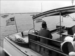 B/W 1961 John + Jacqueline Kennedy on cabin cruiser pulling away from dock / Hyannis Port Stock Footage
