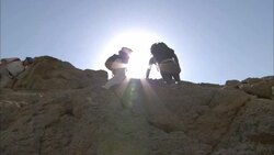 Hikers trek across the ruins of Shenshef, Egypt under a blazing sun. Stock Footage