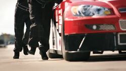 Pit-crew team pushes race-car Stock Footage