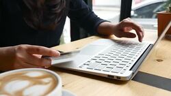 Young Woman using laptop to shop online by credit card with Laptop in Cafe Stock Footage