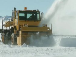 MS TS TD of snow plough working in icy landscape with mountains / Union Glacier, Heritage Range, Ellsworth Mountains, Antarctica  Stock Footage