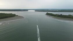 Small boats pass through the ocean entrance to the Murik Lakes Stock Footage