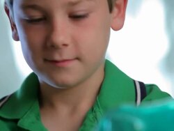 Boy Puts Money in Piggy Bank Stock Footage