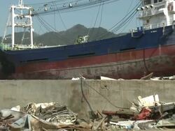 Large ship rests amoung burnt out area of Kessenuma city after huge fire during tsunami.  filmed on 1 April 2011, 3 weeks after tsunami which was caused by magnitude 9 Tohoku earthquake off north east Japan / AUDIO Stock Footage