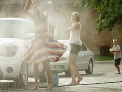 Slow motion medium shot of people having water fight / Pleasant Grove, Utah, United States Stock Footage