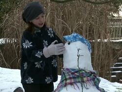 MS Girl making nose of snowman / Saarburg, Rhineland-Palatinate, Germany Stock Footage