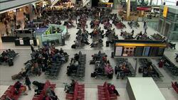 Passengers sitting in Heathrow departure lounge News Clip