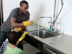 Couple at sink doing plumbing Stock Footage