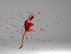 slow motion of Ballerina jumping through red flowers petals Stock Footage