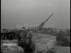 1940: BRITISH DEFENSE: XWS Dover Cliffs harbor sea BG. British soldiers manning anti-aircraft cannons. British soldier standing looking through w/ binoculars. WS Anti-aircraft guns sea BG. AERIAL: British bomber airplanes in-flight. WWII Instructional Video