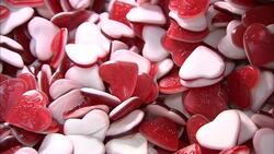 A metal scoop selects red and white heart shaped candies from a bin. Stock Footage