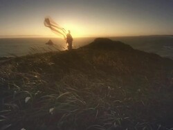 MS SLO MO POV Woman with cape in wind by Ocean at sunset / Cape Blanco, Oregon, United States Stock Footage