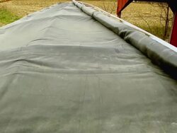 MS PAN Cover puting over length of truck and farmer siting on tractor  / Chelsea, Michigan Stock Footage