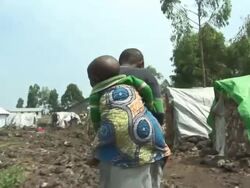 A boy carrying a baby on his back Stock Footage