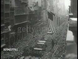1933: U.S. NATIONAL RECOVERY ADMINISTRATION: CU Man drawing 'NRA' poster (eagle logo). HA XWS NRA parade. WS Officials at stand. HA WS Paraders walking, large crowds. Instructional Video