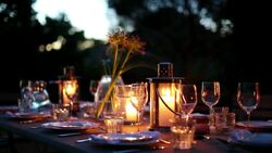 Table with luxury place settings in backyard at night Stock Footage