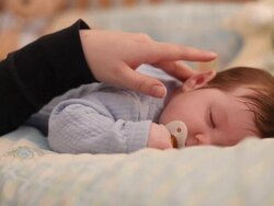 Mother caressing young infant Stock Footage
