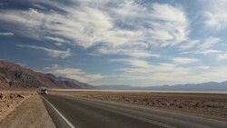 A car on the road near Badwater which is the lowest point in the USA being 282 feet below sea level in Death Valley. Death Valley is the lowest, hottest, driest place in the USA, with an average annual rainfall of around 2 inches, some years it does not re Stock Footage
