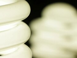 Timelapse close up zoom out and track up of a spiral fluorescent energy saving electric light bulb flickering on and off Stock Footage