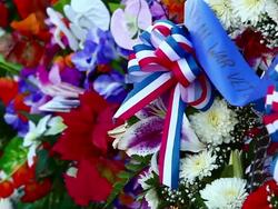 Close-up pan of flowers and flags at the Korean War Veterans Memorial in Washington DC Stock Footage