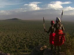 Maasai or Samburu Two warriors stand at high point looking over amazing African landscape Stock Footage