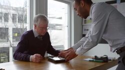 MS Businessman presenting project on digital tablet to mature businessman in office conference room Stock Footage