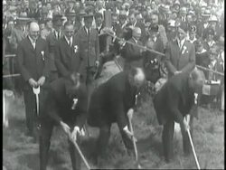 Three men in suits hack at the dirt with pickaxes during the groundbreaking ceremony for the George Washington Bridge. News Clip
