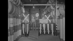 Warehouse workers at 'railroad crossing' of miniature railroad conveyor system inside Chicago Tribune's paper storage warehouse News Clip
