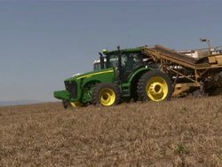 Telephoto close up of the combine and the tractor-trailers passing by. Stock Footage