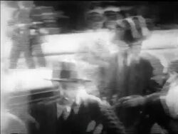 B/W 1930 PAN police leading Legs Diamond with head down on street Stock Footage