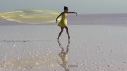 Young ballerina dancing on the salt lake with color tulle Stock Footage