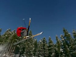 Slow motion wide shot freestyle skier doing back flip off ramp Stock Footage
